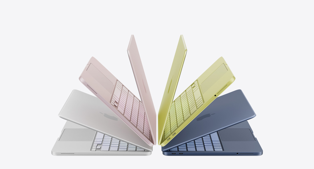 银色、桃粉色、柑橘黄色和靛蓝色 MacBook Neo 笔记本电脑呈略微打开状态，排列成一个拱形。
