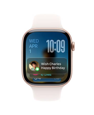 玫瑰金色 Apple Watch Series 11，搭配淡桃粉色表带，表盘左上角显示日期，右上角显示时间，底部显示信息小组件。