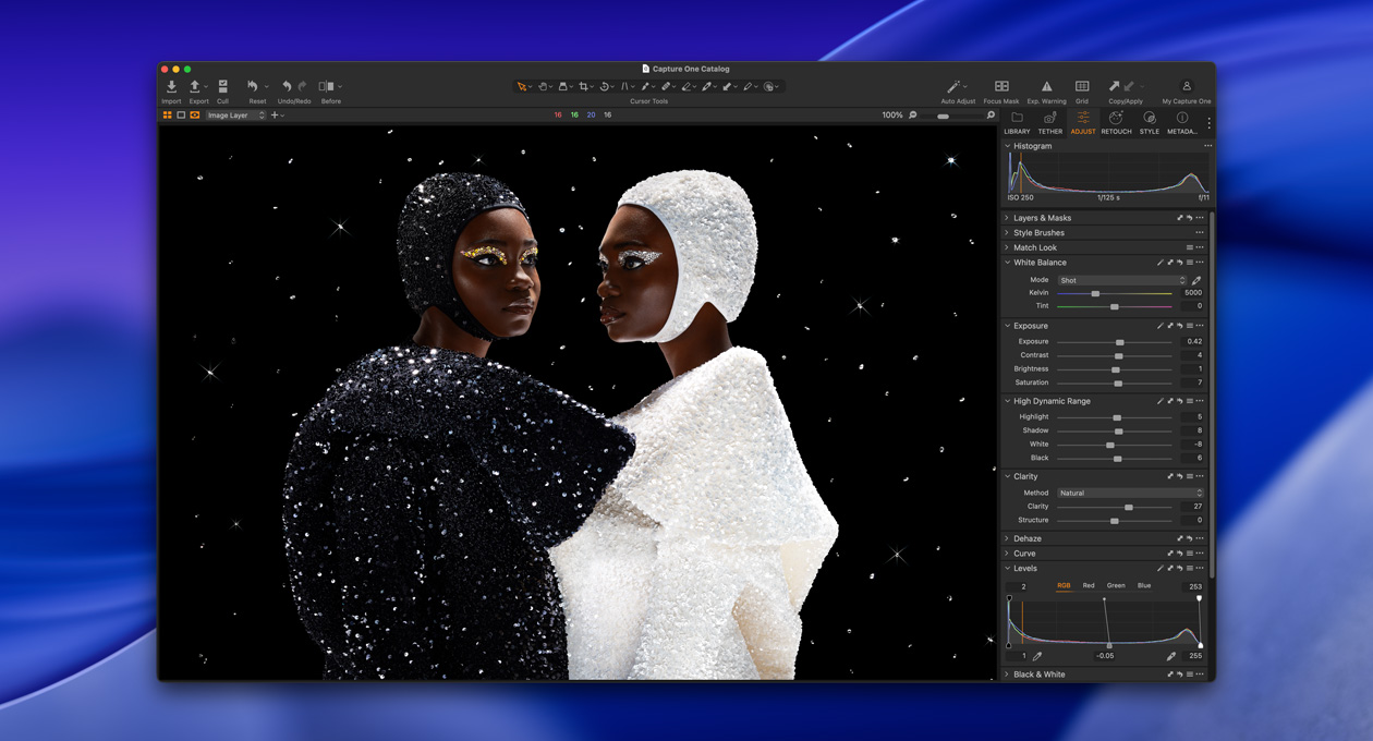 一个身穿黑衣的人和一个身穿白衣的人呈倾角并排站立，展示 Studio Display XDR 实现的亮度和对比度。