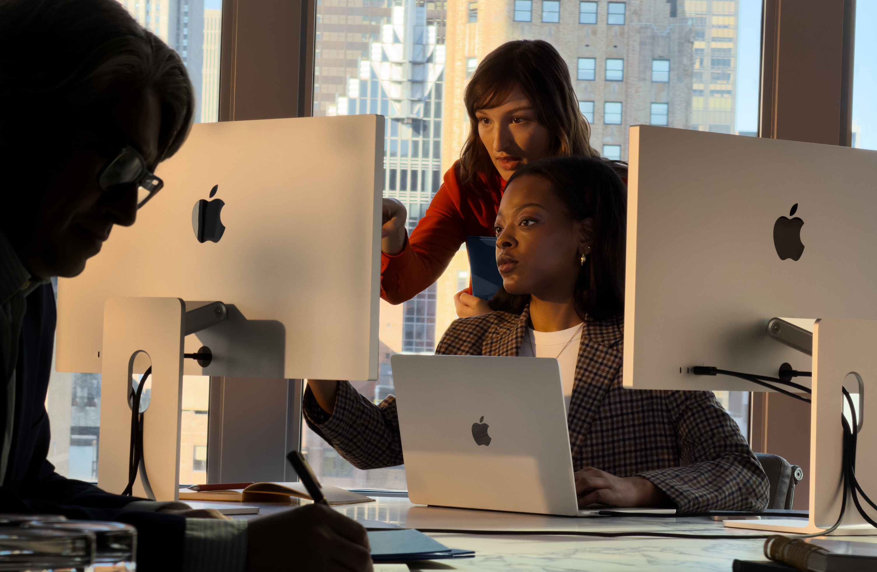 工作场景中，人们正在使用 Mac。