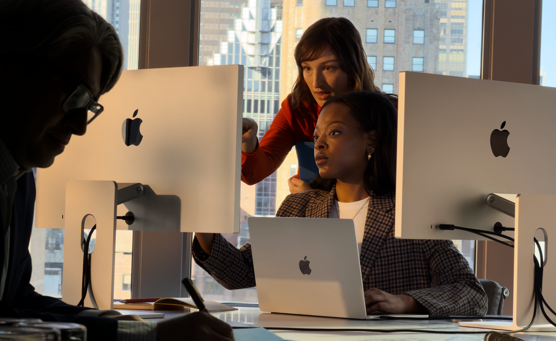 工作场景中，人们正在使用 Mac。