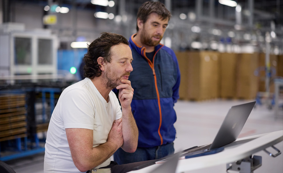 两个人正在通过一台笔记本电脑进行协作或学习