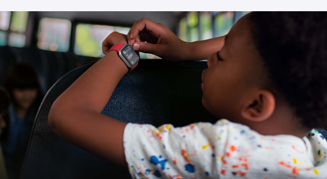 一个孩子正在读 Apple Watch SE 上的消息。