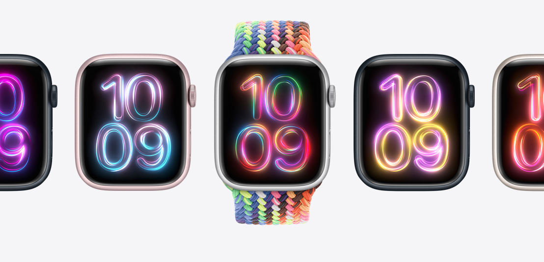 多款 Apple Watch Series 9，中间的表款搭配新款彩虹版编织单圈表带，表带上呈现多彩霓虹图案。每款手表均使用不同配色的 Pride Radiance 表盘。