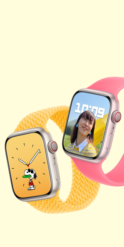 两支 Apple Watch Series 9。第一支显示史努比表盘并配有艳阳色编织单圈表带。第二支显示人像表盘并配有粉色单圈表带。